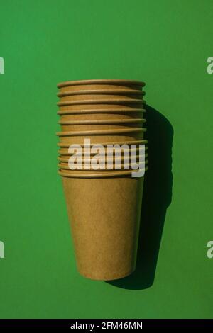 Empty recyclable paper cups on green background. Many takeaway cups for drink. Eco friendly. Zero waste Plastic free concept. Stock Photo