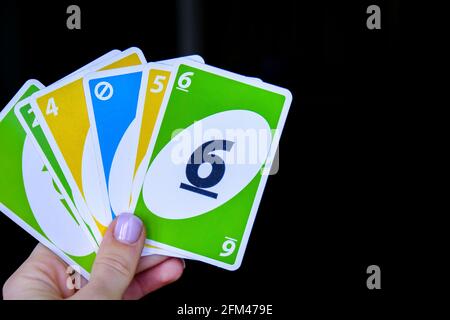 Kiev, Ukraine - 10.03.2021 Playing cards UNO in female hand. Table games. Pastime. Board games. Stay home leisure activity for kids. Stock Photo