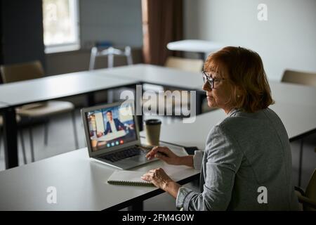 Female business manager getting distracted from online call Stock Photo