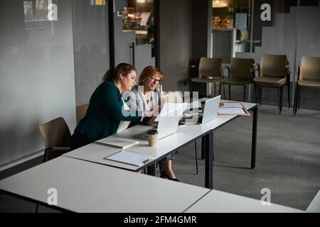 Female employee drawing attention of director to paper Stock Photo