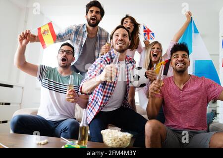 Excited fans of soccer friends celebrating winning match Stock Photo