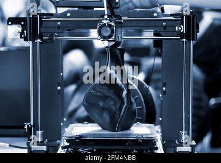 3D printer printing a model in the form of black vase close-up. Stock Photo