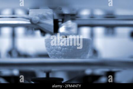 Work 3d printer close up. Printing 3D printer Object plastic On blue background. Stock Photo