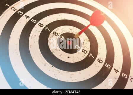 Dart in bulls eye of dartboard with shallow depth of field concept for hitting target Stock Photo