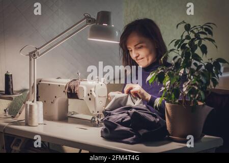 Dressmaker With Sewing Machine In Her Studio Stock Photo, Picture