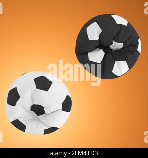 Two black and white armchairs in the form of a soccer ball on orange background. Top view. 3d rendering Stock Photo