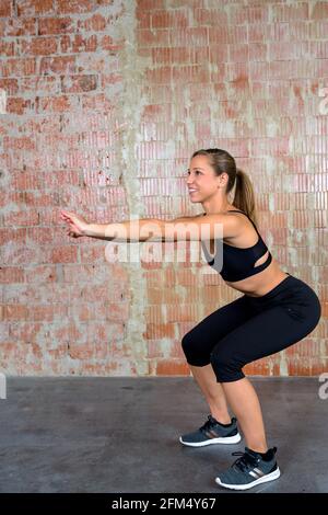 Happy woman doing squats and exercising indoors Stock Photo