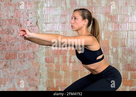 Athletic european woman doing squats Stock Photo