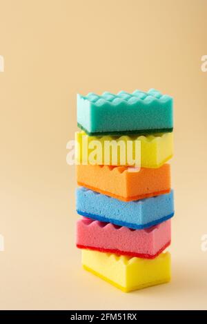 Stack of multicolored dishwashing sponges on neutral beige background, kitchen household and cleaning concept Stock Photo