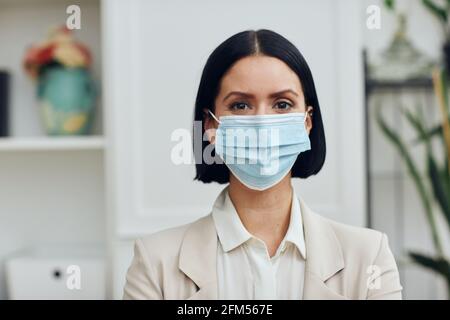 young woman wearing medical mask and protective face masks at home Stock Photo