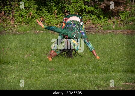 A fit nimble woman in her 50s at a meditative Yoga class in a park in Flushing, Queens, New York City. Stock Photo
