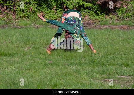 A fit nimble woman in her 50s at a meditative Yoga class in a park in Flushing, Queens, New York City. Stock Photo