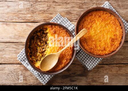 Pastel de choclo corn pie is a Chilean dish based on sweetcorn and beef closeup in the pots on the table. Horizontal top view from above Stock Photo