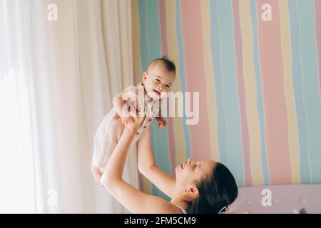 Young mother hugs her mixed race child. Child adoption and In Vitro Fertilization IVF . Stock Photo