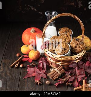 Homemade pumpkin spicy muffins with nuts and raisin, pumpkins and spices on rustic dark background. Autumn and winter baking. Stock Photo
