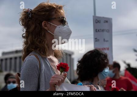 Athens, Greece. 6th May, 2021. Members of PAME the workers' union affiliated with the Greek Communist Party, KKE, hold carnations and wave flags in front of the parliament. Thousands took to the streets to honor May Day and protest against the labor market deregulation and the abolition of the 8 hour work day. Credit: Nikolas Georgiou/ZUMA Wire/Alamy Live News Stock Photo