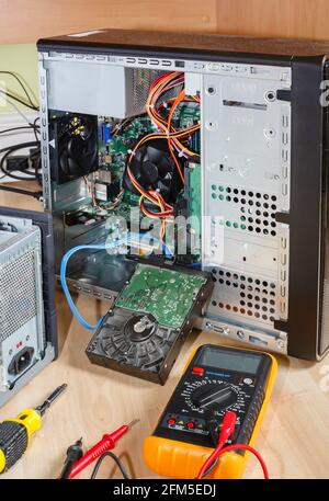 Repairing or upgrading a computer. Tower PC with open side and hard drive removed. UK office Stock Photo