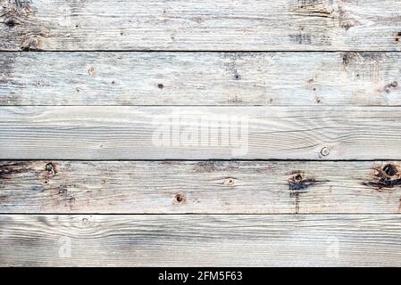 Texture of the planks of an old wooden table in antiqued light pastel colors. Vintage rustic wooden background. Carpentry. Stock Photo