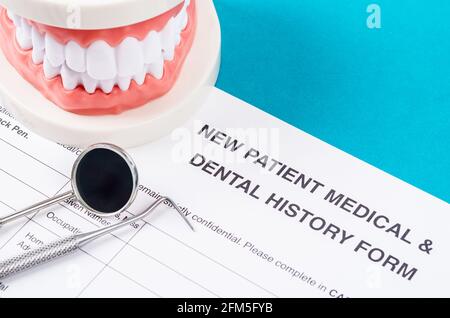 New patient medical form with model tooth and dental instruments. Dental health and teeth care concept. Stock Photo