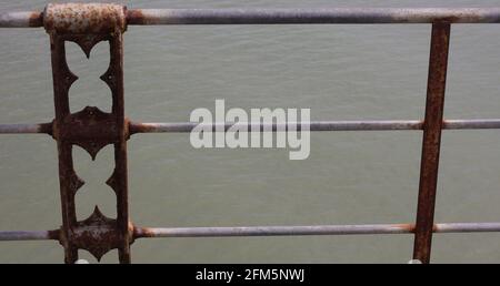 Close up of rusted railing with grey space between horizontal bars. Stock Photo