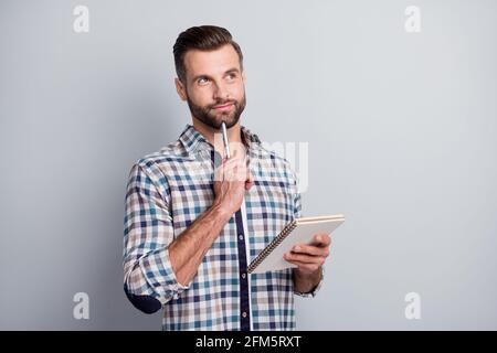 Portrait of attractive cheery minded focused guy wear checked shirt creating new strategy isolated over gray pastel color background Stock Photo
