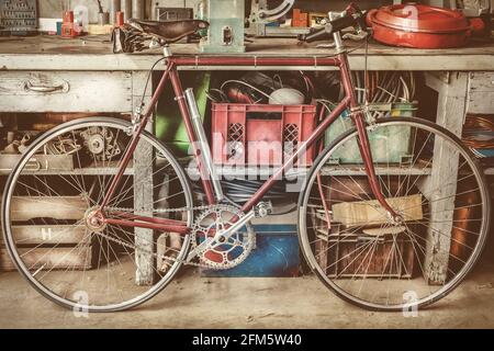 Vintage racing bycicle in front of an old work bench with tools in a garage Stock Photo