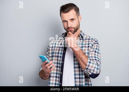 Portrait of nice attractive minded bearded guy using device creating post isolated over gray pastel color background Stock Photo