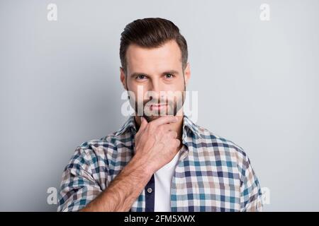 Photo portrait of thoughtful man wearing plaid shirt touching chin isolated on grey color background Stock Photo