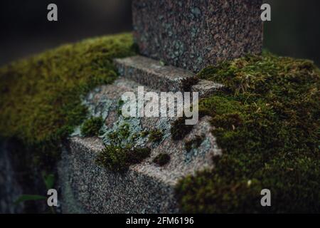 base of a large granite tombstone grave marker in a cemetery. Natural light Stock Photo