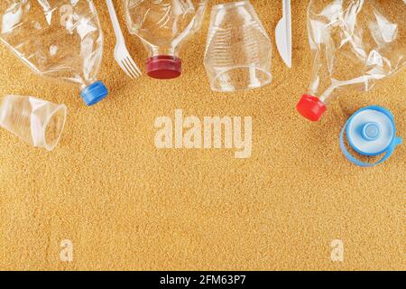 Trash from plastic bottles on a sandy beach with free space. Global environmental pollution. space for text Stock Photo