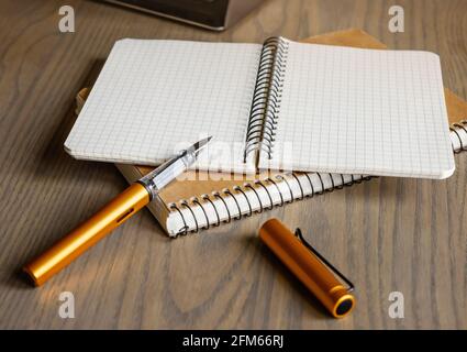 Ink pen with notebooks on a wooden table. Stock Photo