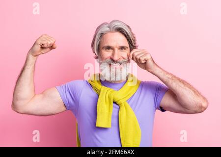 Photo of aged man happy smile show hands muscles sportive strong tied sweater isolated over pink color background Stock Photo