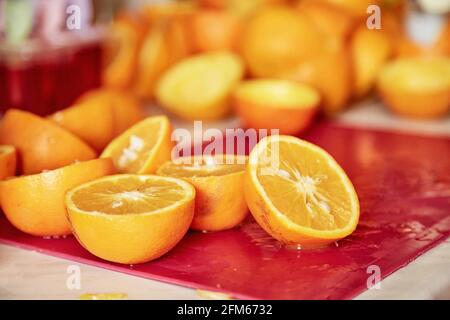 Halves of a chopped orange. Preparation for preparing freshly squeezed juice. Bright background. Vegetarianism. The concept of proper nutrition.  Stock Photo