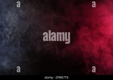 Artificial smoke in white-red light on a black background Stock Photo