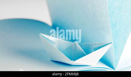 Origami, Paper boat on sheet Stock Photo