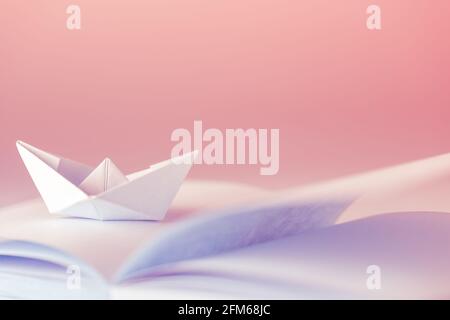 Origami, Paper boat on sheet Stock Photo