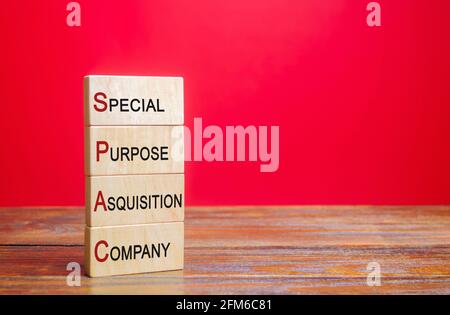 Wooden blocks with the word SPAC - Special purpose acquisition company. Simplified listing of company, merger bypassing stock exchange IPO. Assessment Stock Photo