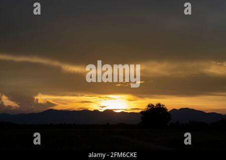 Senset moment view behind the mountain in the golden light from the sun. Stock Photo
