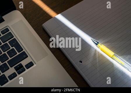 pen in a ray of light and notebook Stock Photo