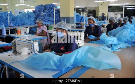 Bangalore, India. 6th May, 2021. Workers process personal protective equipment (PPE) kits for hospitals at a factory in Bangalore, India, on May 6, 2021. Due to growing demands for PPE kits, employees of this factory are working around the clock in double shifts. Credit: Str/Xinhua/Alamy Live News Stock Photo