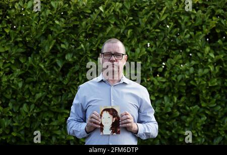 Mark Kelly holds a photograph of his his 12 year old sister Carol-Ann who he saw die after being struck by a plastic bullet in Belfast in 1981. Mr. Kelly has said the British Government cannot be allowed to block future legal cases as bereaved families in Northern Ireland pursue justice for their loved ones. He was speaking following reports that the UK Government is set to introduce a statute of limitations on prosecutions for conflict crimes that occurred pre-1998. Picture date: Thursday May 6, 2021. See PA story ULSTER TroublesVictims. Stock Photo