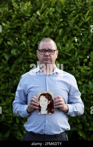 Mark Kelly holds a photograph of his his 12 year old sister Carol-Ann who he saw die after being struck by a plastic bullet in Belfast in 1981. Mr. Kelly has said the British Government cannot be allowed to block future legal cases as bereaved families in Northern Ireland pursue justice for their loved ones. He was speaking following reports that the UK Government is set to introduce a statute of limitations on prosecutions for conflict crimes that occurred pre-1998. Picture date: Thursday May 6, 2021. See PA story ULSTER TroublesVictims. Stock Photo