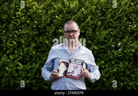 NOTE CONTENT IN PHOTO Mark Kelly, who saw his 12 year old sister Carol-Ann die after being struck by a plastic bullet in Belfast in 1981, holds a photograph of her when she was alive and a booklet showing a photograph of her in her coffin. Mr. Kelly has said the British Government cannot be allowed to block future legal cases as bereaved families in Northern Ireland pursue justice for their loved ones. He was speaking following reports that the UK Government is set to introduce a statute of limitations on prosecutions for conflict crimes that occurred pre-1998. Picture date: Thursday May 6, 20 Stock Photo