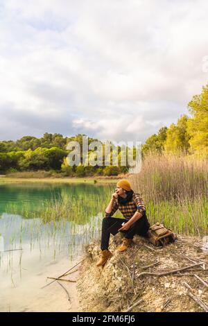 traveler contemplating beautiful scenery sitting looking at the lake Stock Photo