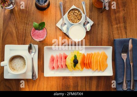 Fresh fruits for breakfast on wooden table. Healthy food concept. Stock Photo