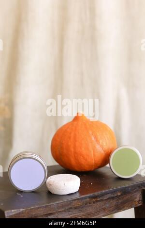 White soap in round aluminum metal tin on neutral background. Natural cosmetic product. Face and body skin care, cosmetic products with pumpkin Stock Photo