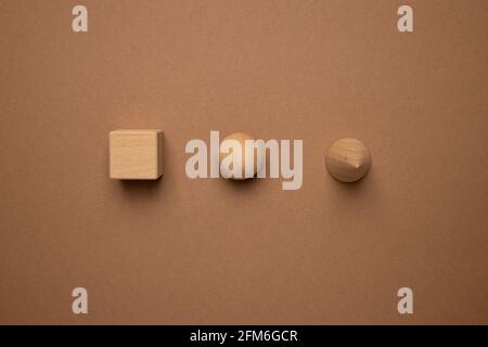 Wooden toy children's sorter with small wooden details in the form of geometric shapes rectangle, square, triangle on a brown background, figure concept Stock Photo