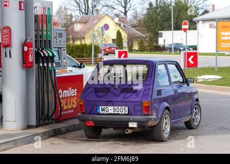 Gulbene, Latvia - May 02, 2021: a colorful vintage car Fiat 126 refueling at the gas station Stock Photo