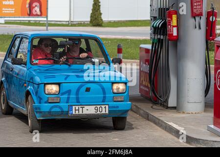 Gulbene, Latvia - May 02, 2021: a colorful vintage car Fiat 126 refueling at the gas station Stock Photo