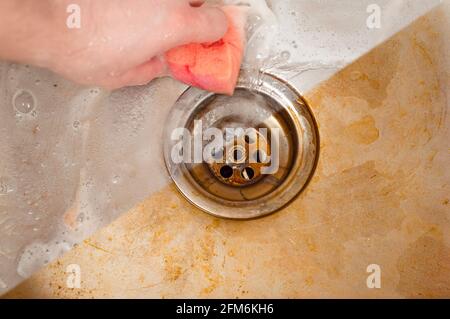 A clear example of the action of a high-quality detergent using the example of a kitchen sink drain. Rubbing with a sponge Stock Photo